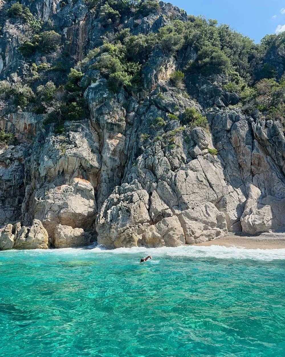 Turquoise water below limestone cliffs on our private boat day from Himarë, Albania