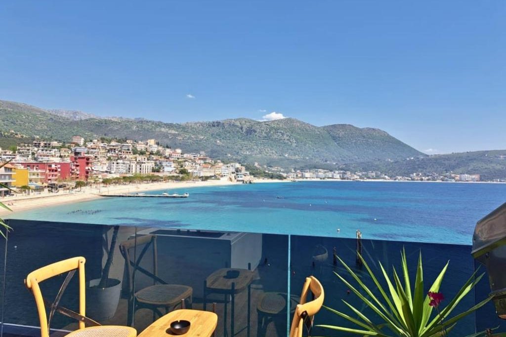 Balcony table and chairs looking along the beach and mountains at Rea Boutique Hotel in Himarë