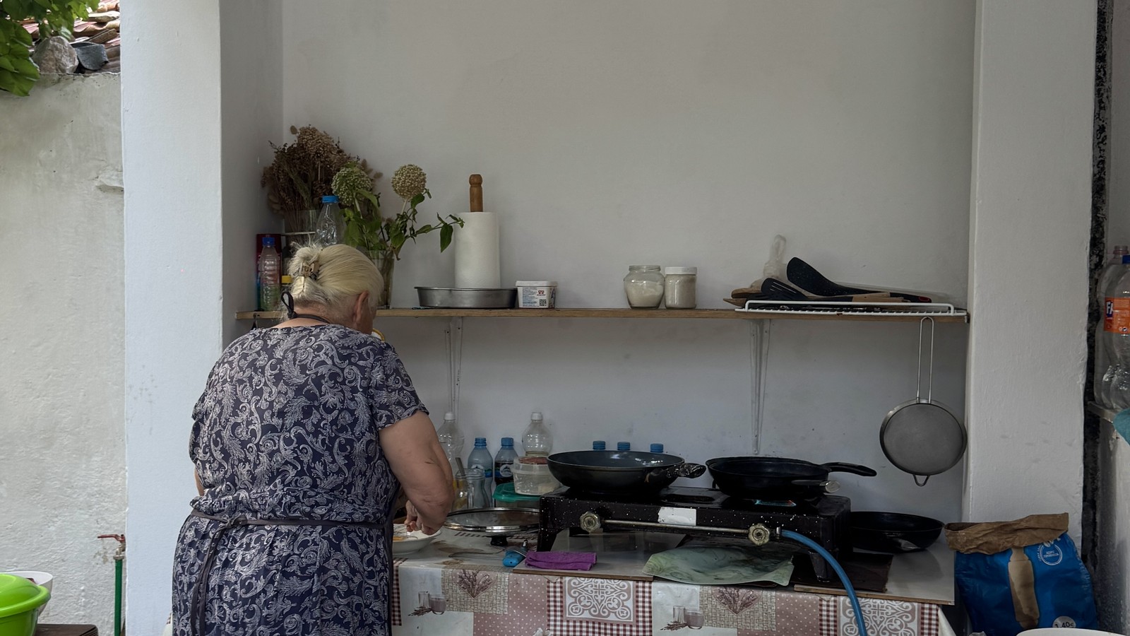 A cook preparing breakfast in a homestay kitchen in the Albanian Alps