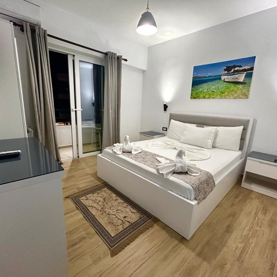 White double bedroom with a window at Hotel Real in Sarandë, Albania