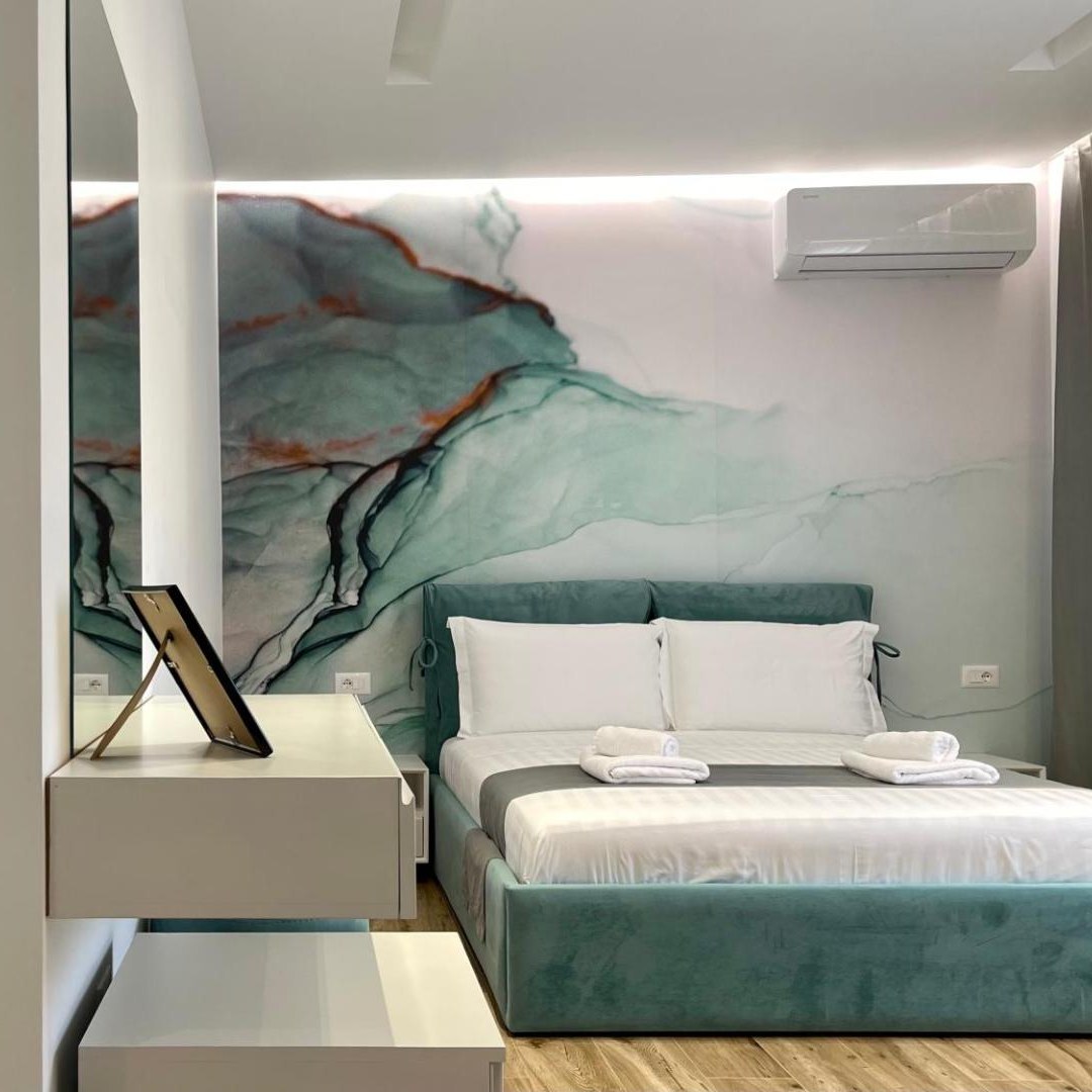 Double bedroom with a painting above the bed at Vila Llanaj in Ksamil, Albania