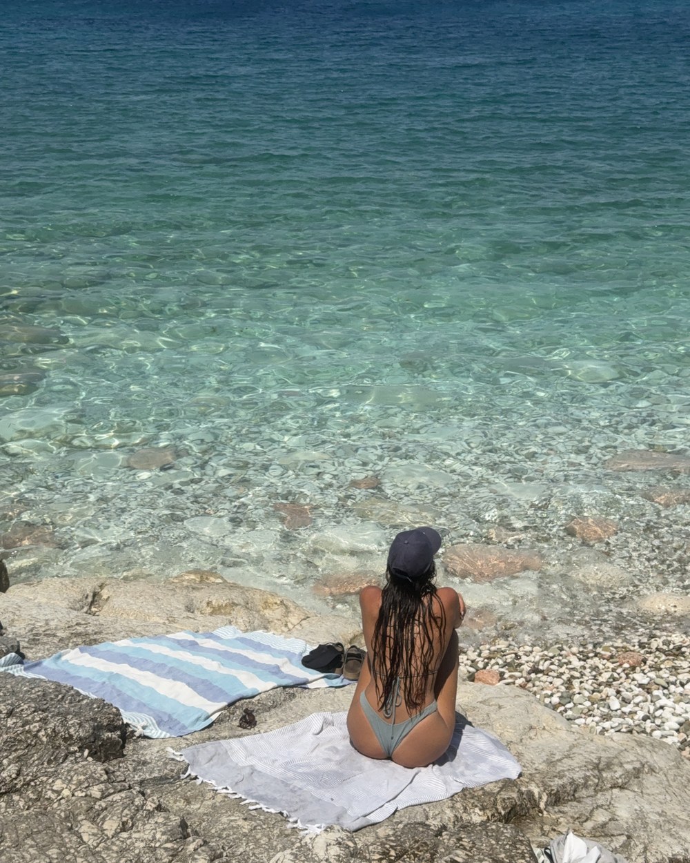 Clear shallow water and pebbles at Pulëbardha Beach between Sarandë and Ksamil