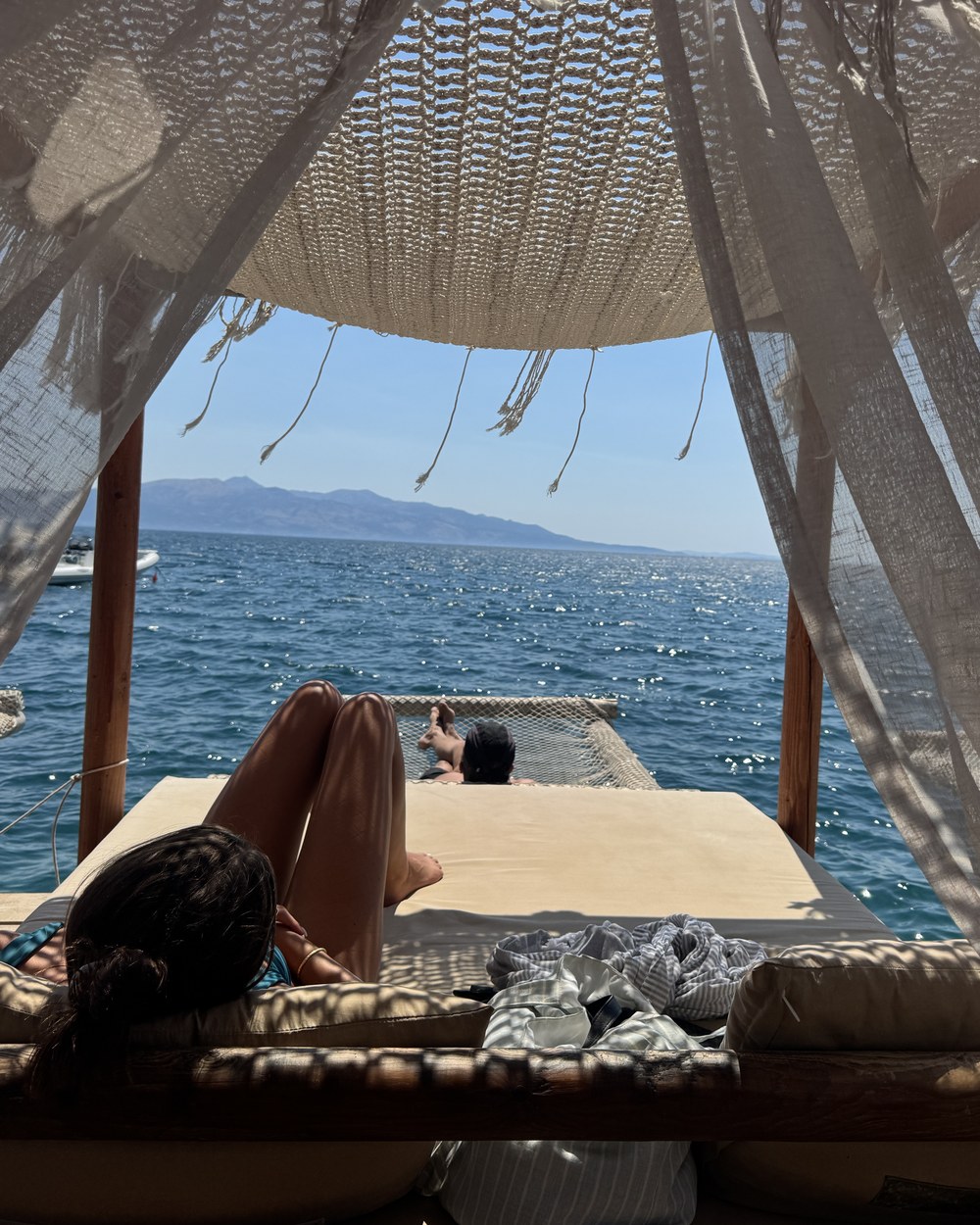 Sunbeds and turquoise water at Crystal Island beach club in Sarandë, Albania