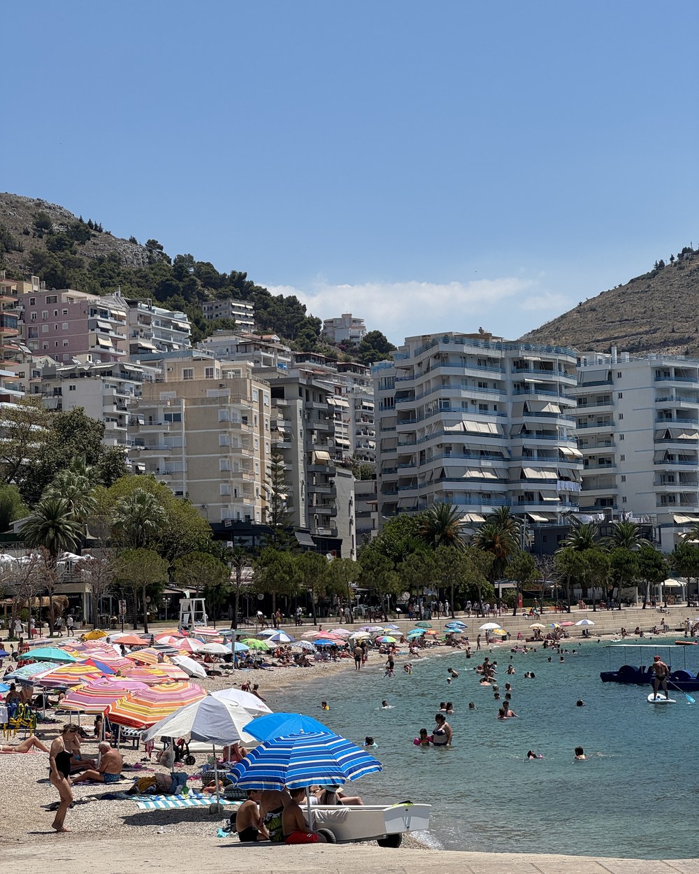 Swimmers and paddleboards in the clear water off Sarandë's main beach, Albania