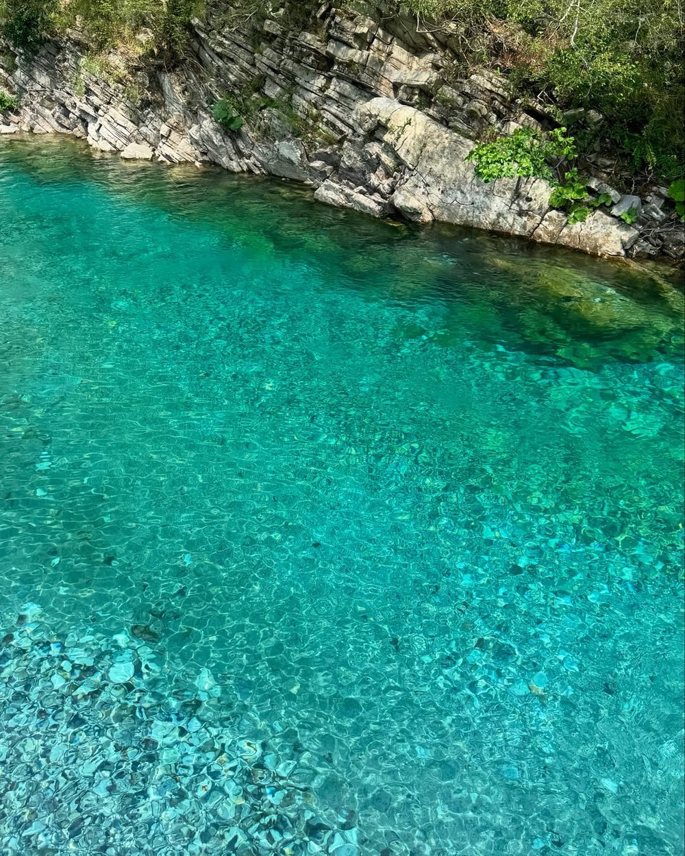 Clear turquoise water over pale pebbles at the Shala River in the Albanian Alps