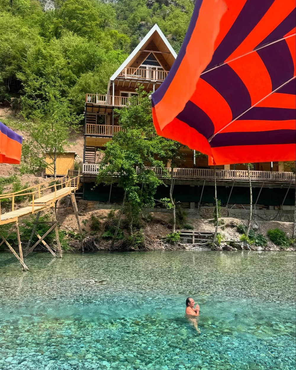 Wooden chalets above the clear turquoise water of the Shala River, Albania