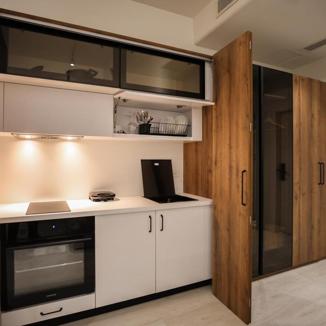 Compact kitchen with white cabinets and an oven at A Gallery Hotel in Shkodër, Albania