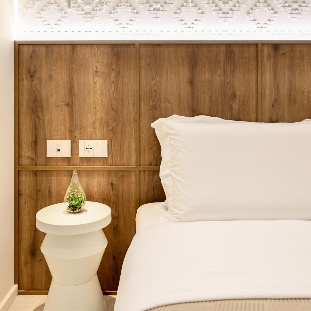 Double bed against a wooden headboard wall at A Gallery Hotel in Shkodër, Albania
