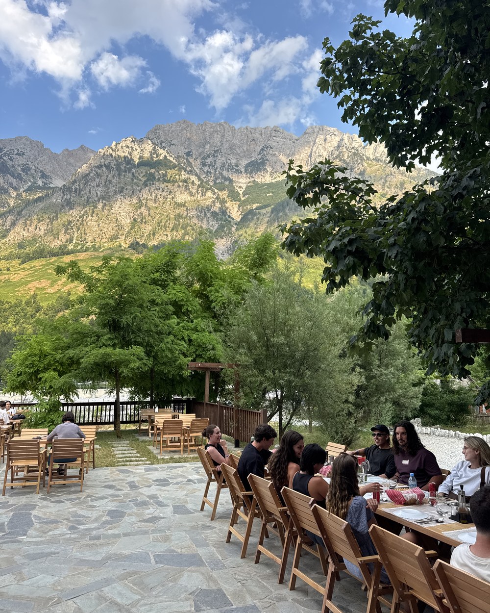 Hikers sharing a long communal dinner table at a guesthouse in Valbonë, Albania