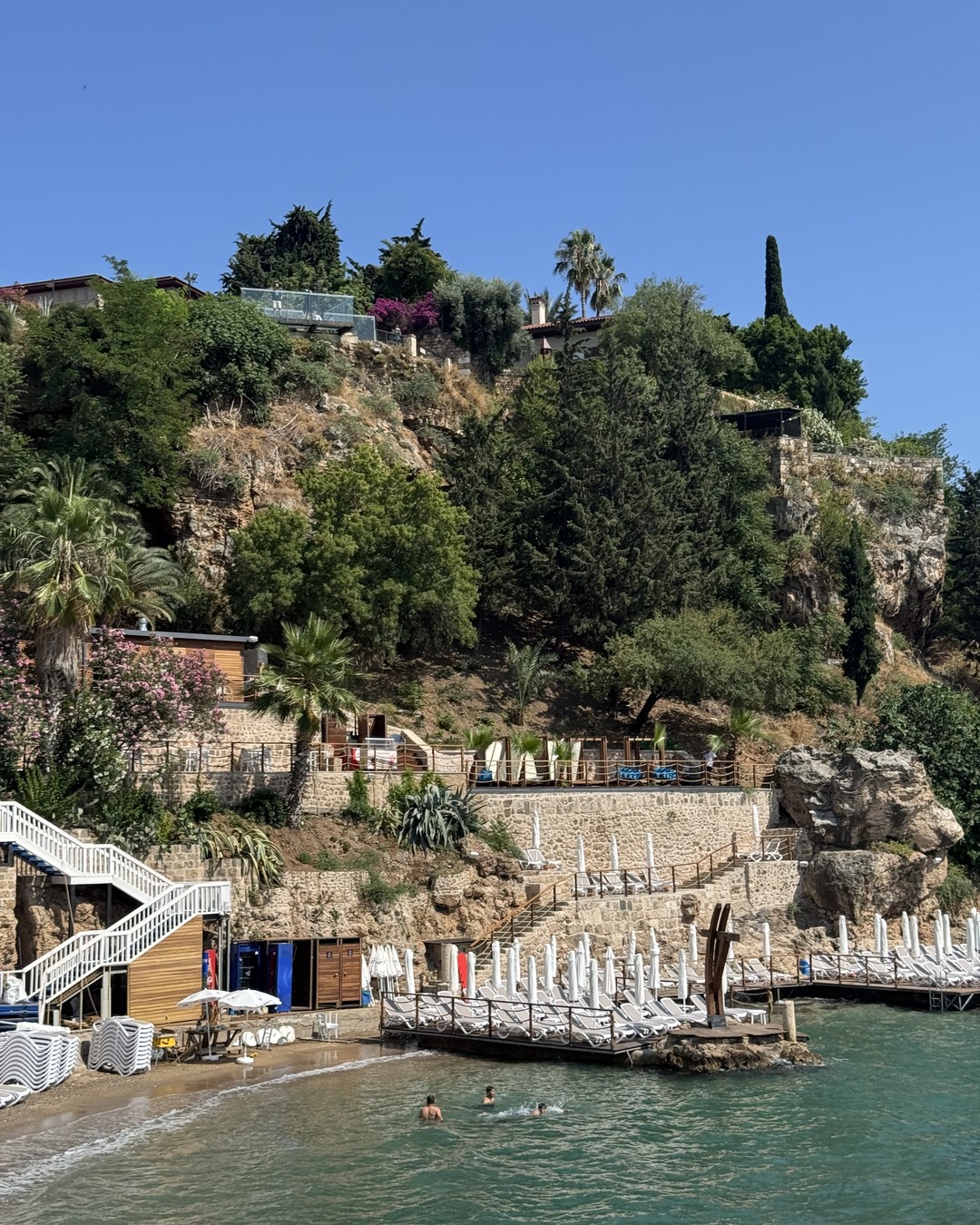 Cliffs above a small beach club and swimming platform in Antalya
