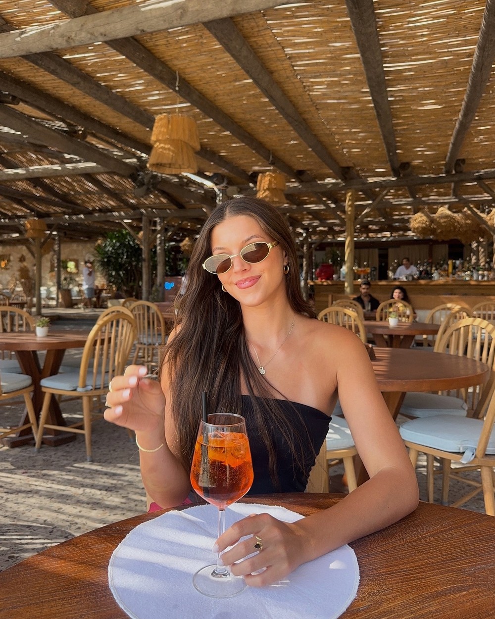 Aperol spritz on a table at a beach club in Bodrum with the bar behind