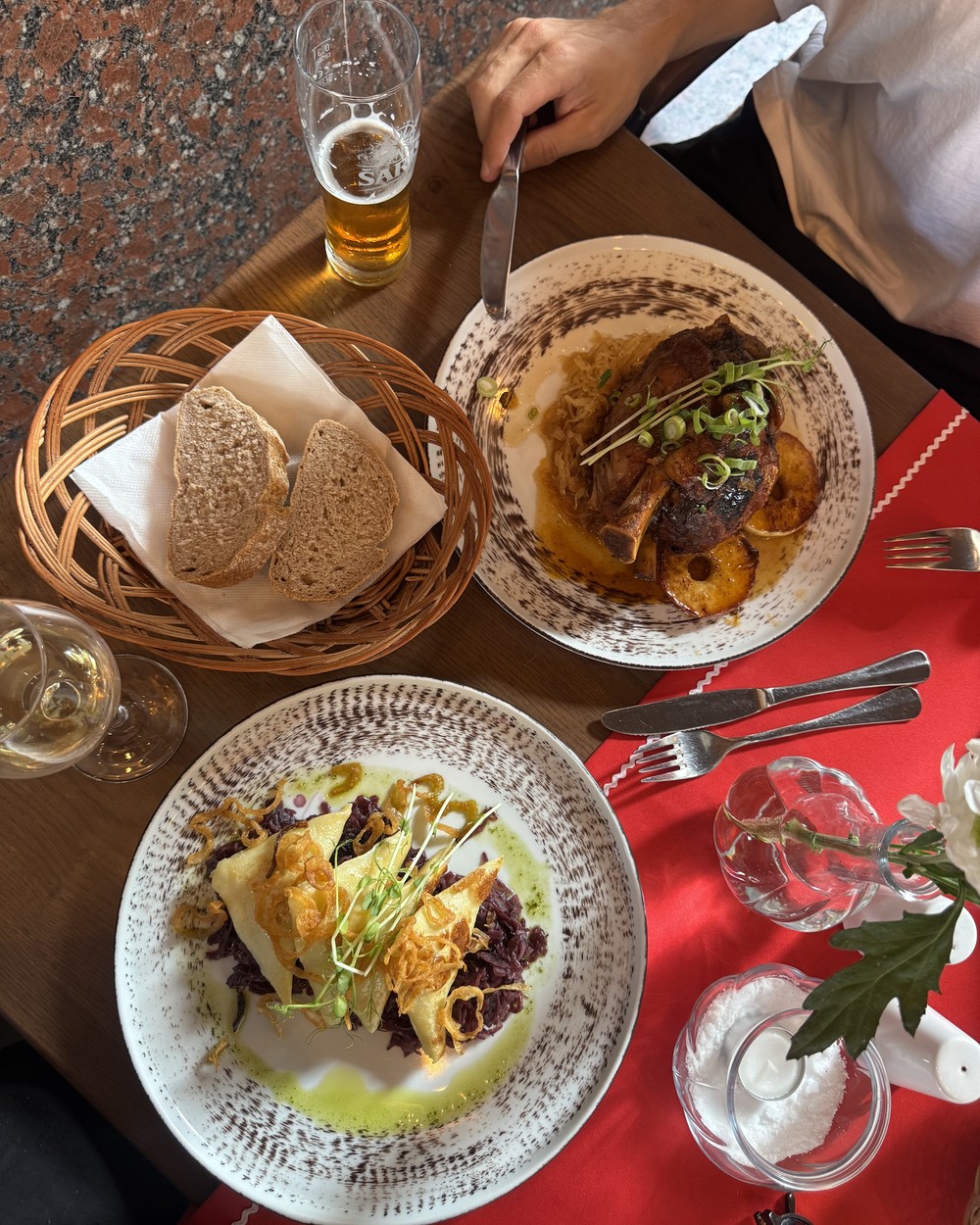 Cheesy garlic soup in a bread bowl, dumplings and a beer on a red table at Slovak Pub, Bratislava