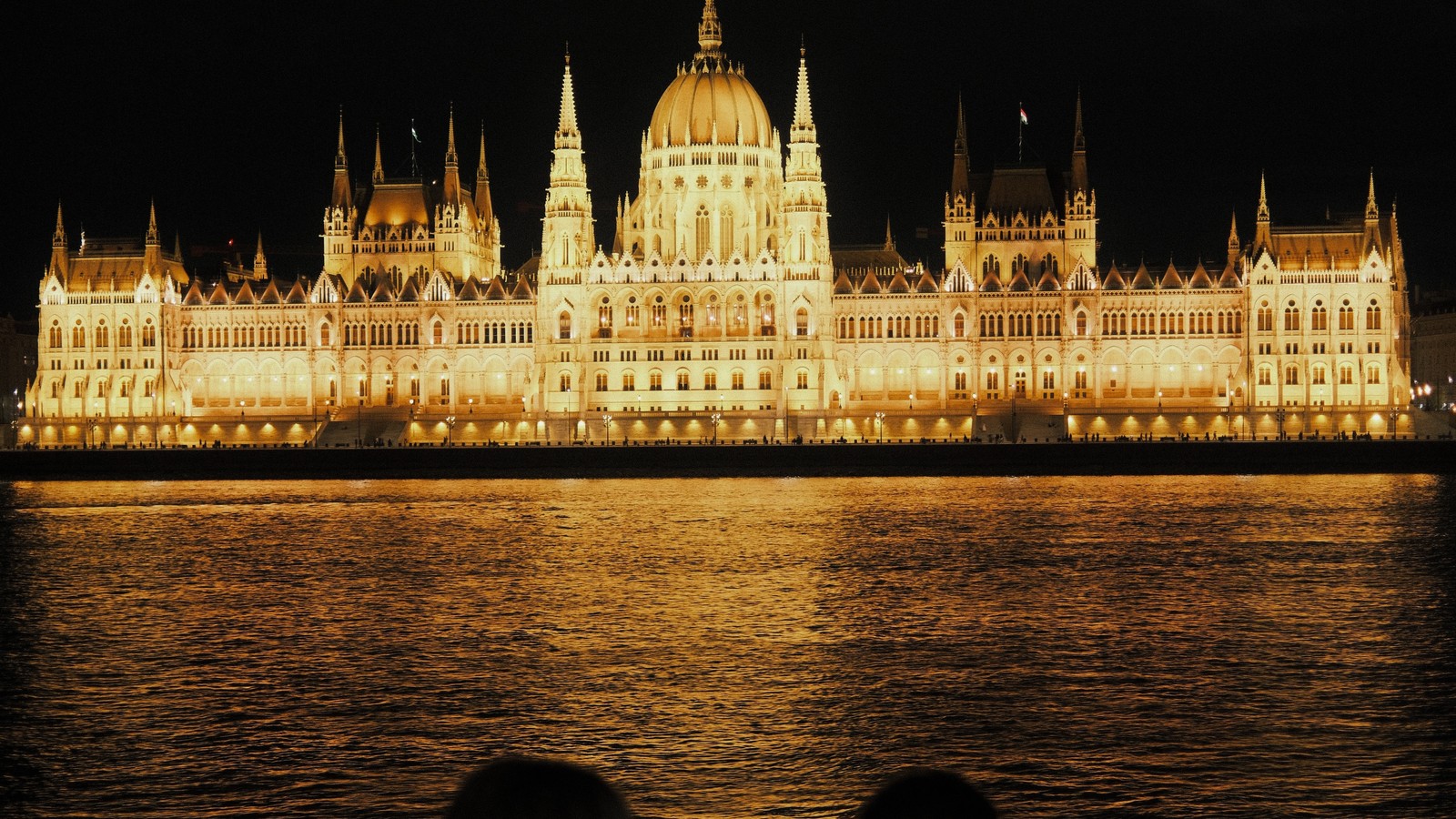 The Hungarian Parliament lit up at night across the Danube in Budapest