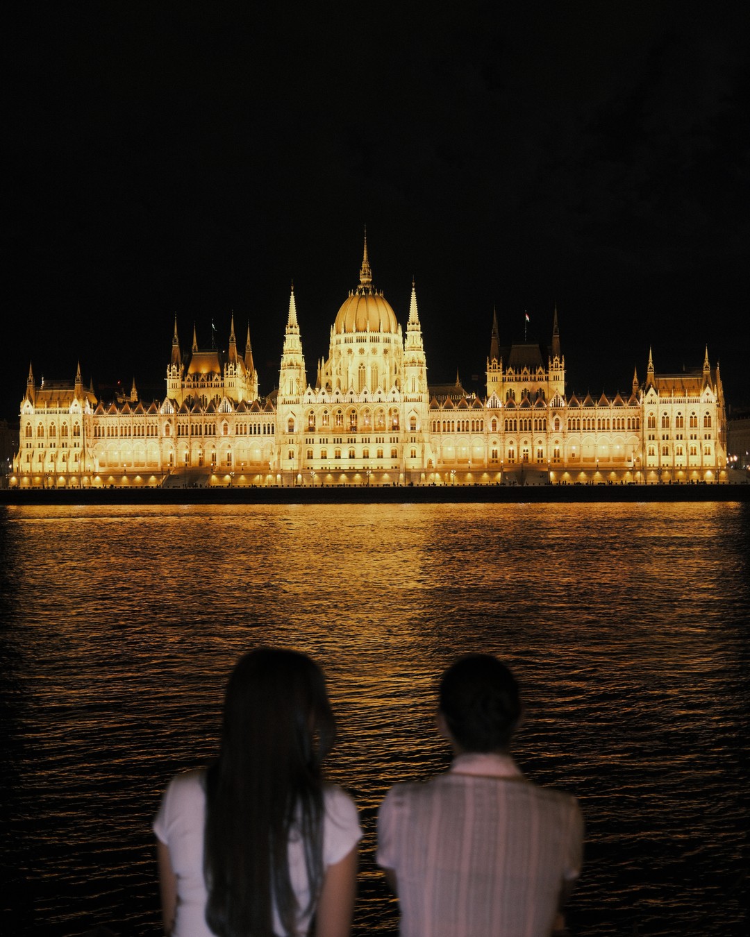 The Hungarian Parliament lit up at night across the Danube in Budapest
