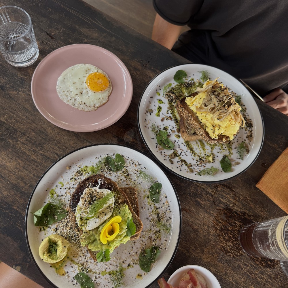 Breakfast plates, toast and drinks on a café table during our travels