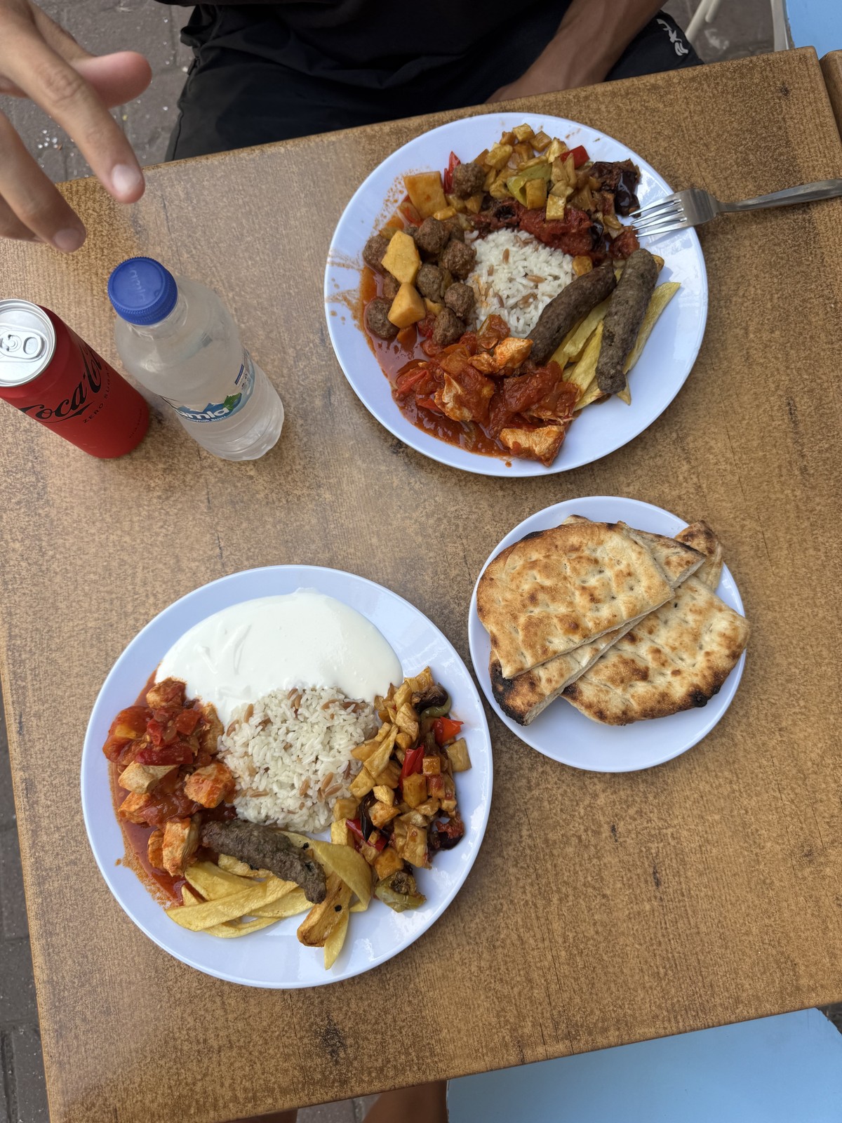 Two plates of Turkish food with rice, vegetables, meat and bread on a table in Antalya