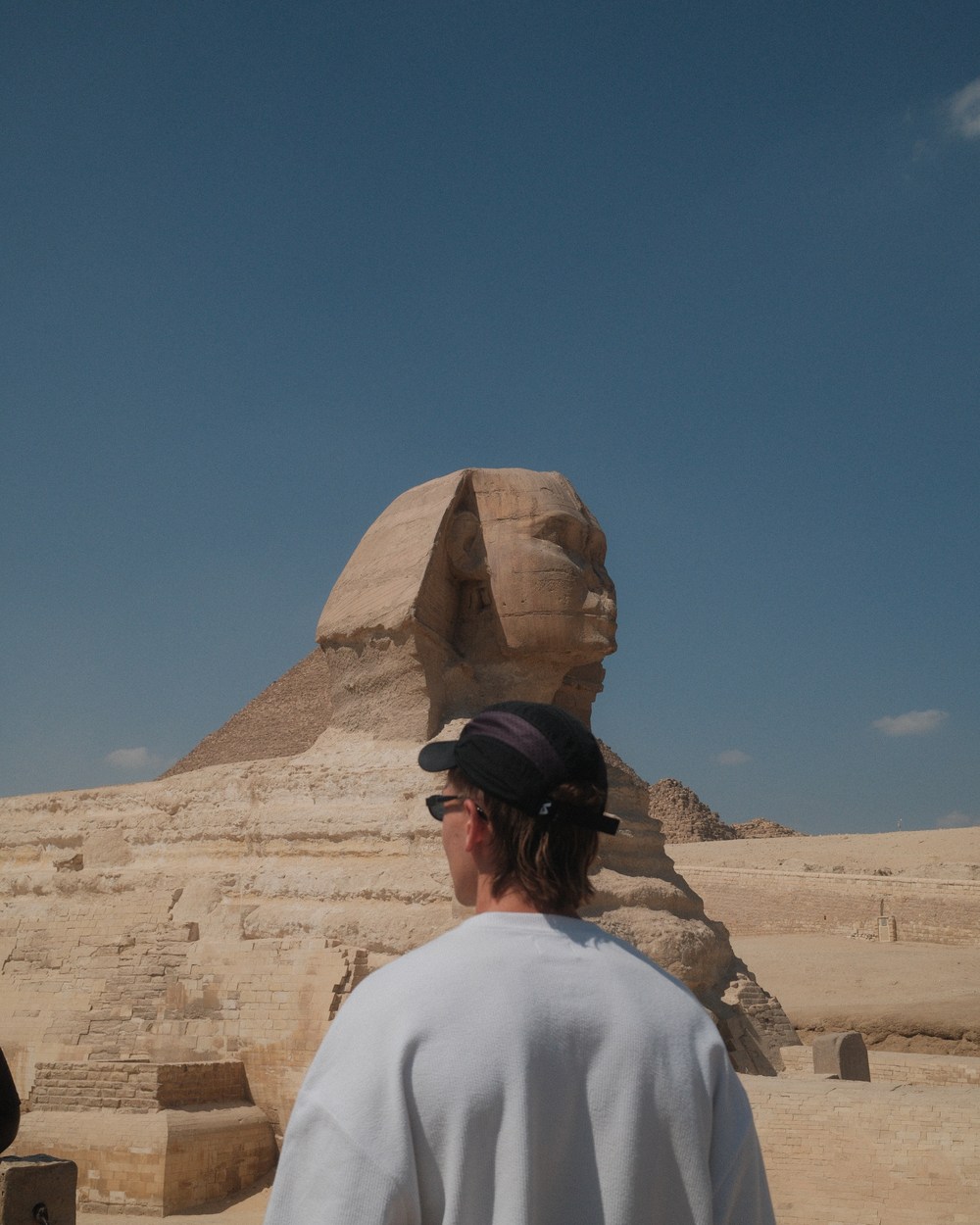 Standing in front of the Great Sphinx of Giza with the pyramid behind, Egypt