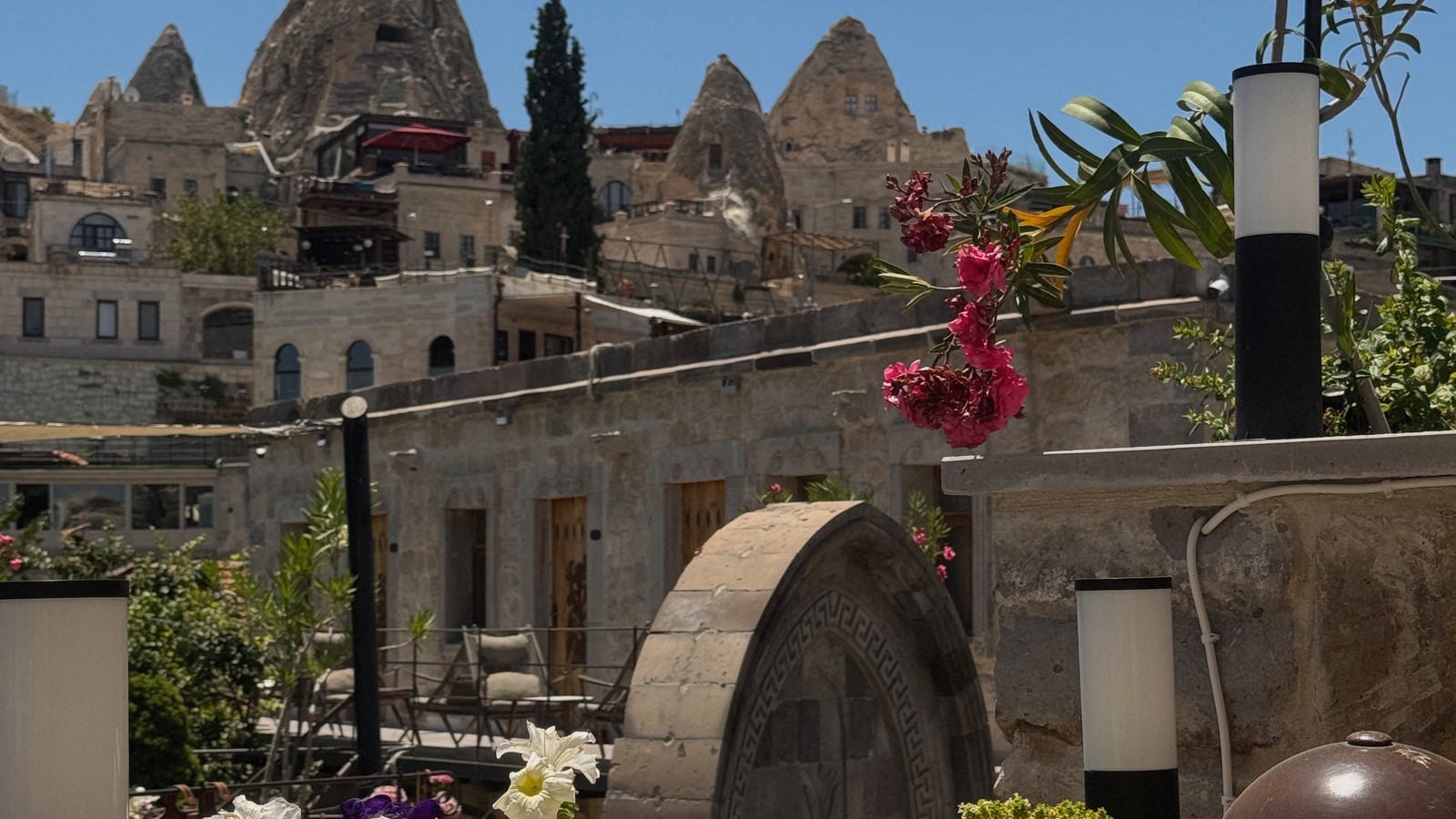 Fairy chimneys and cave houses seen over a flower-filled terrace in Cappadocia