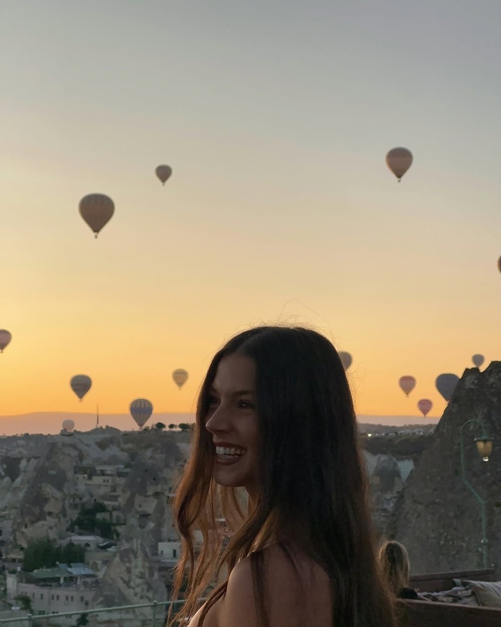 Rock formations and cave houses of Cappadocia at sunset with the valley behind