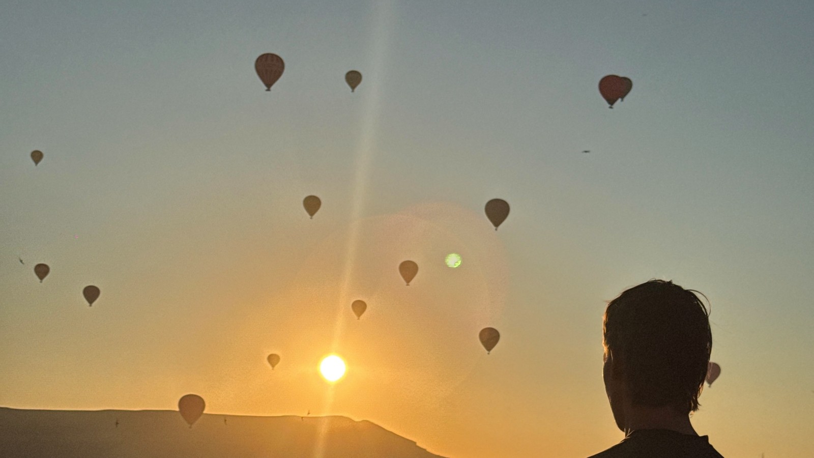 Hot air balloons rising over the valley at sunrise in Cappadocia, Türkiye