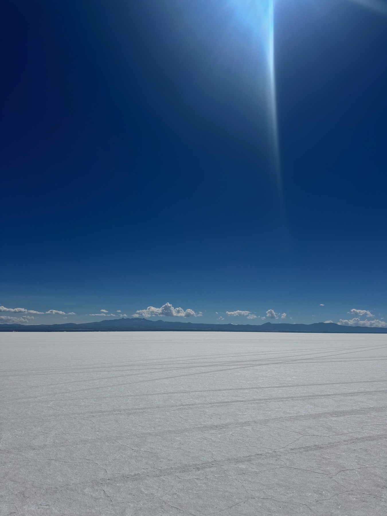 Dry salt patterns stretching towards mountains at Salar de Uyuni