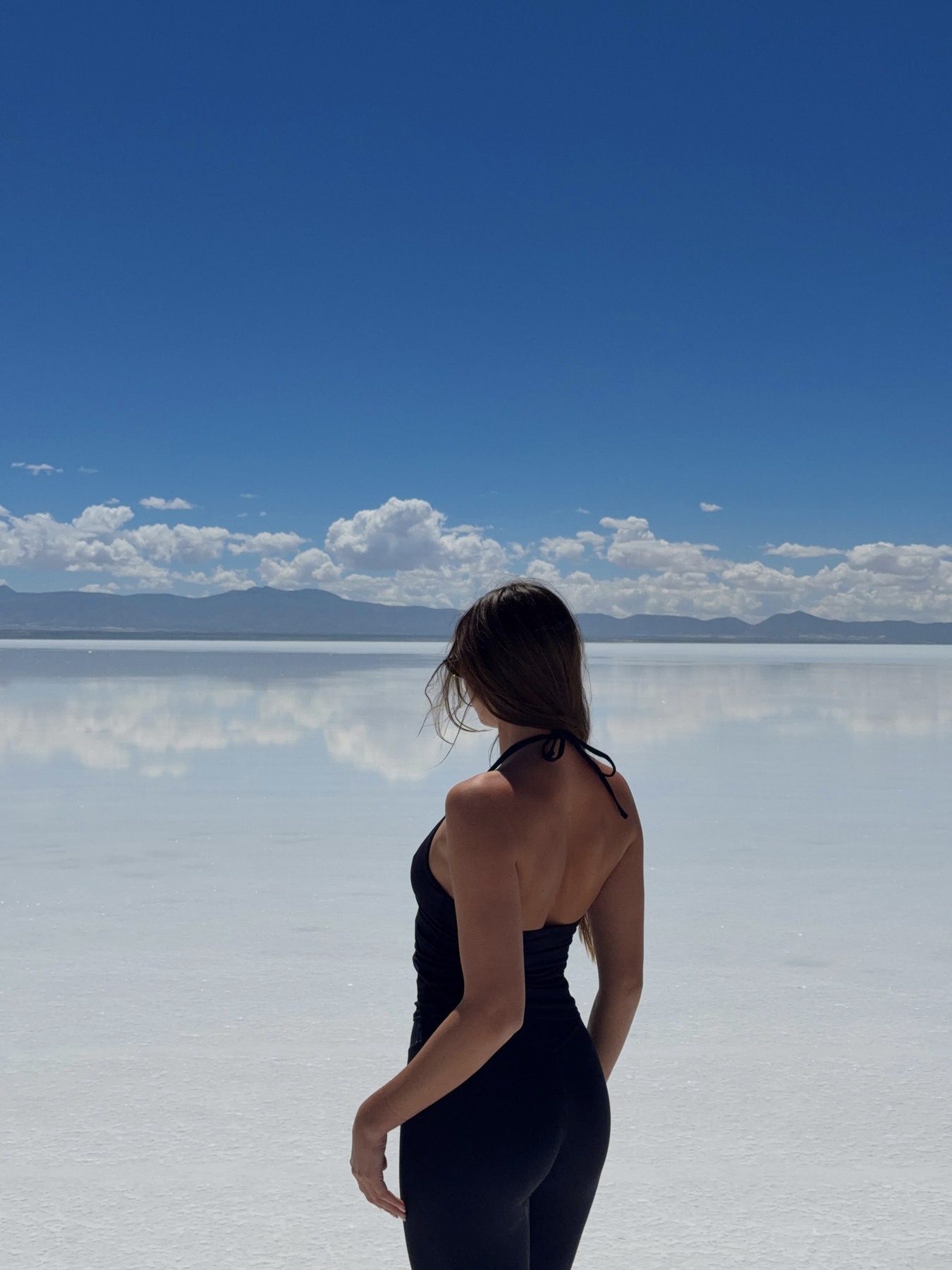 Ellen looking across clouds reflected on the Uyuni salt flats