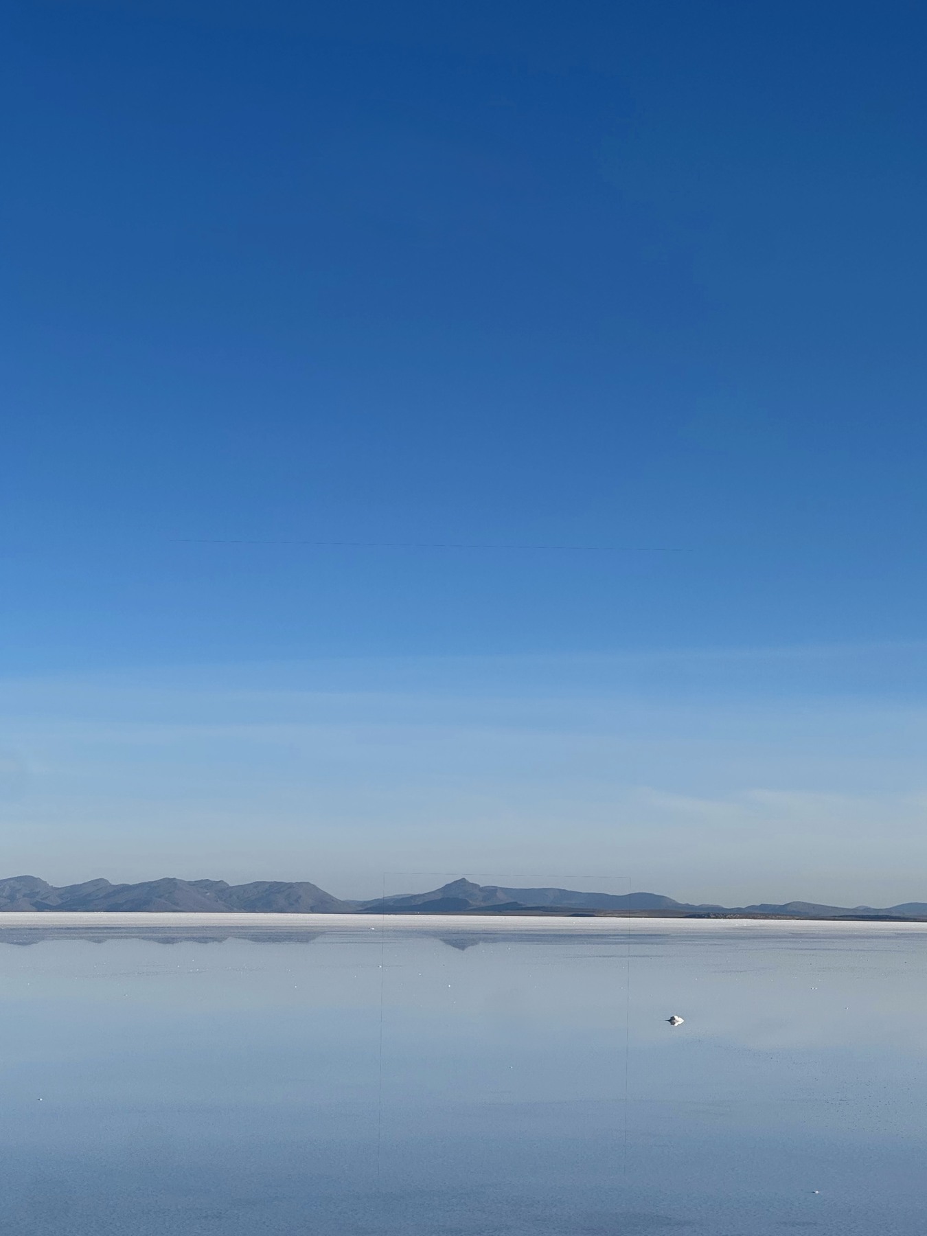 Mountain reflections across shallow water on the Uyuni salt flats