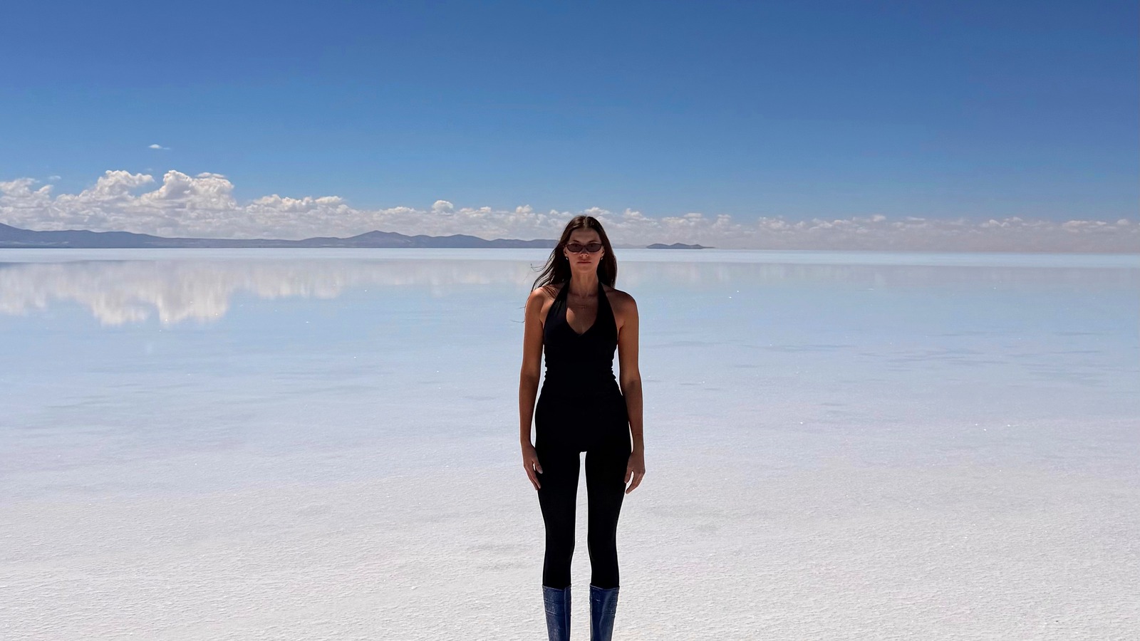 Ellen standing on the bright white Uyuni salt flats in daylight