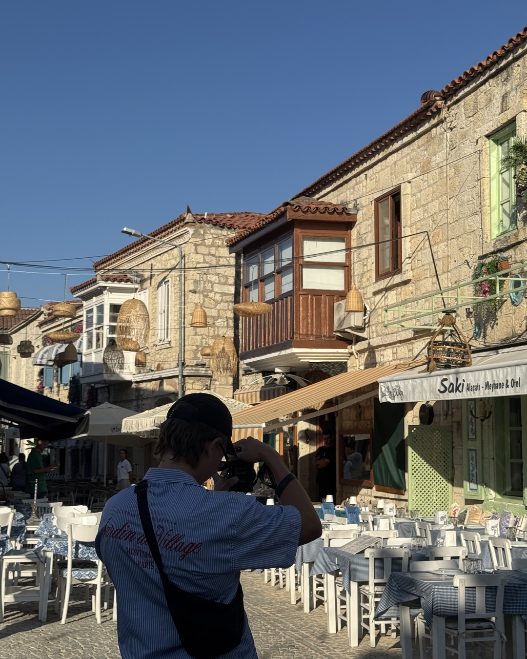 Cobbled street with restaurants and bougainvillea in Alaçatı
