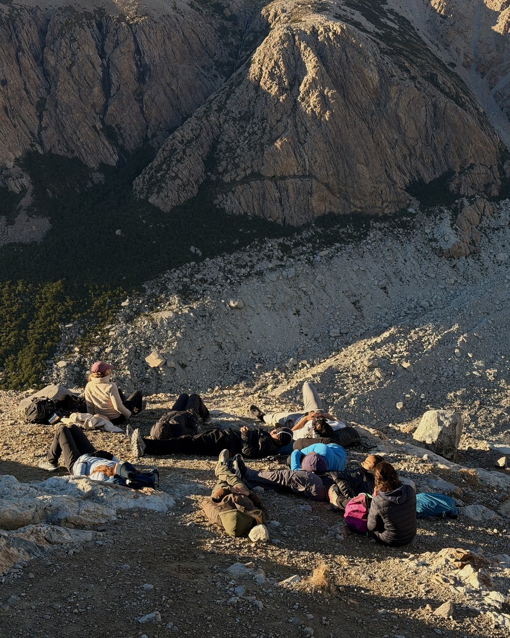 Hikers resting on the rocks at the top after sunrise
