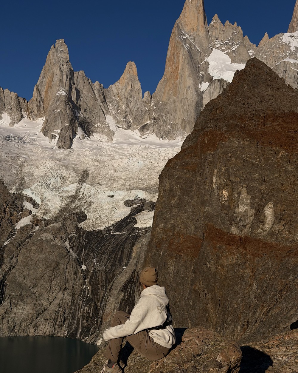 Ellen sitting on a rock below the jagged Fitz Roy skyline