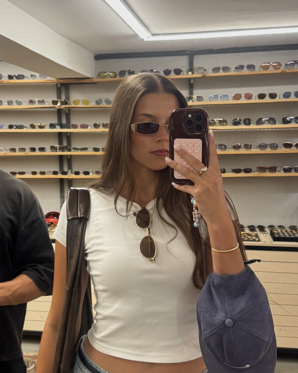 Woman in a vintage shop lined with shelves of sunglasses in Galata, Istanbul