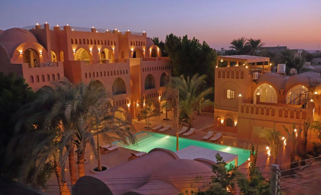 Boutique buildings and illuminated swimming pool at Malkata House in Luxor