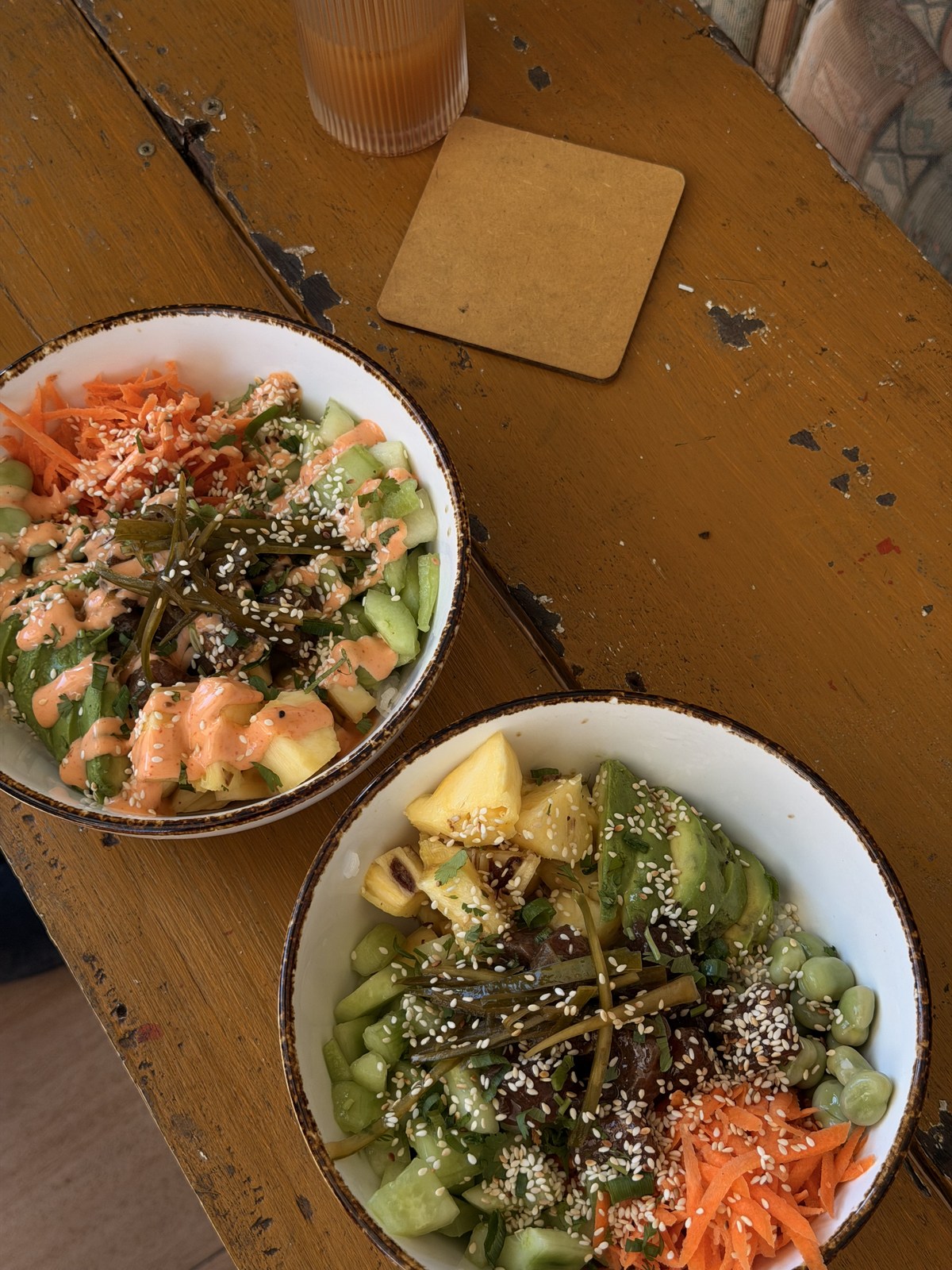Two colourful bowls of food on a wooden café table in Mauritius