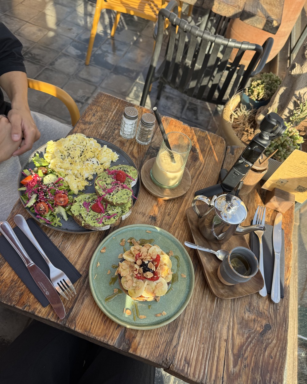 Brunch of eggs, salad and fresh bread on a wooden cafe table in Marrakech, Morocco