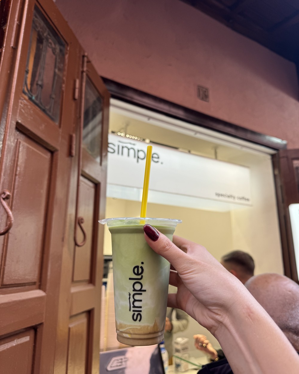Iced matcha in a takeaway cup held up outside a speciality coffee shop in Marrakech, Morocco