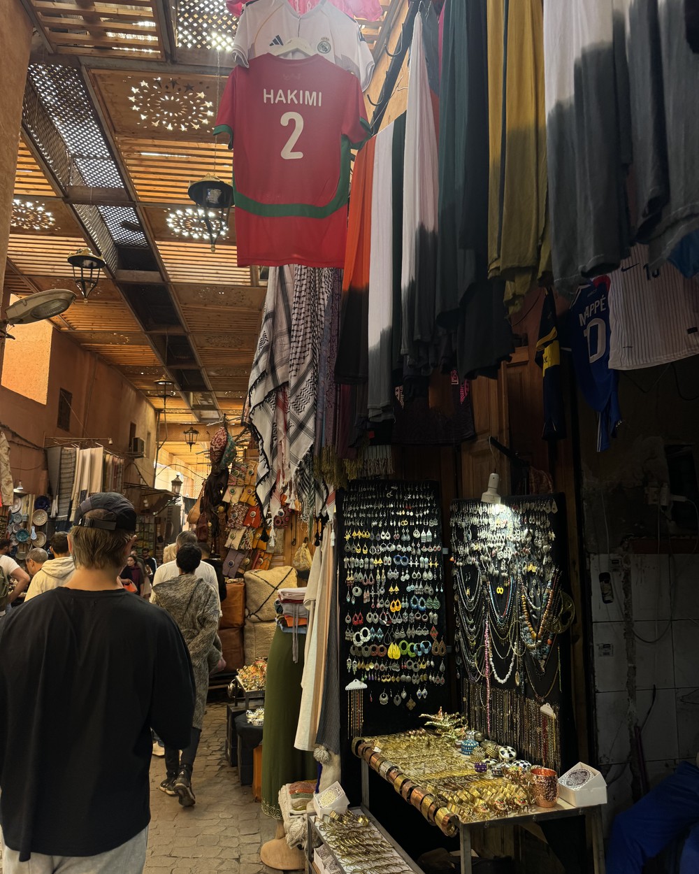 Narrow souk lane lined with shops and hanging goods in the Marrakech medina, Morocco