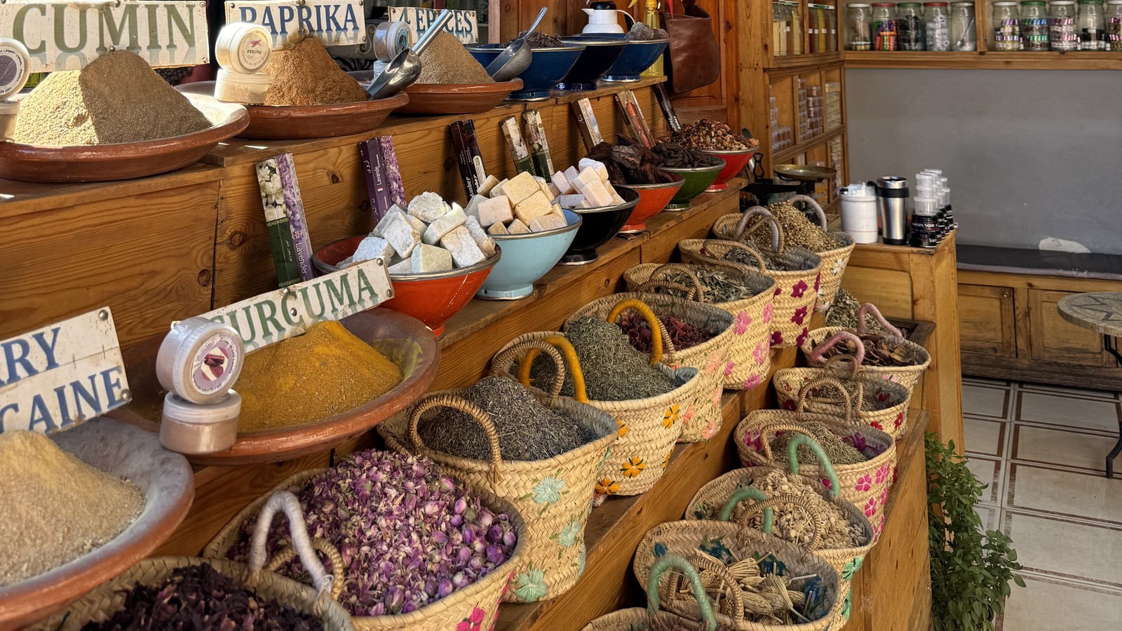 Baskets of cumin, paprika, turmeric and dried rose petals on a spice stall in the Marrakech souks, Morocco