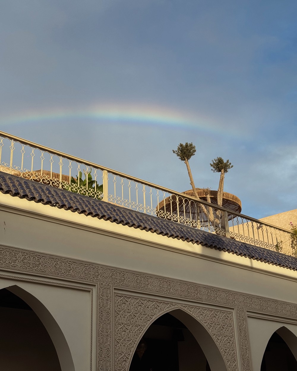Rainbow over the rooftops of the Marrakech medina seen from a riad roof terrace, Morocco
