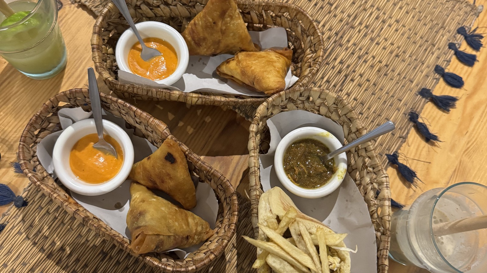 Moroccan pastries and dips served in woven baskets on a table in Tamraght, Morocco