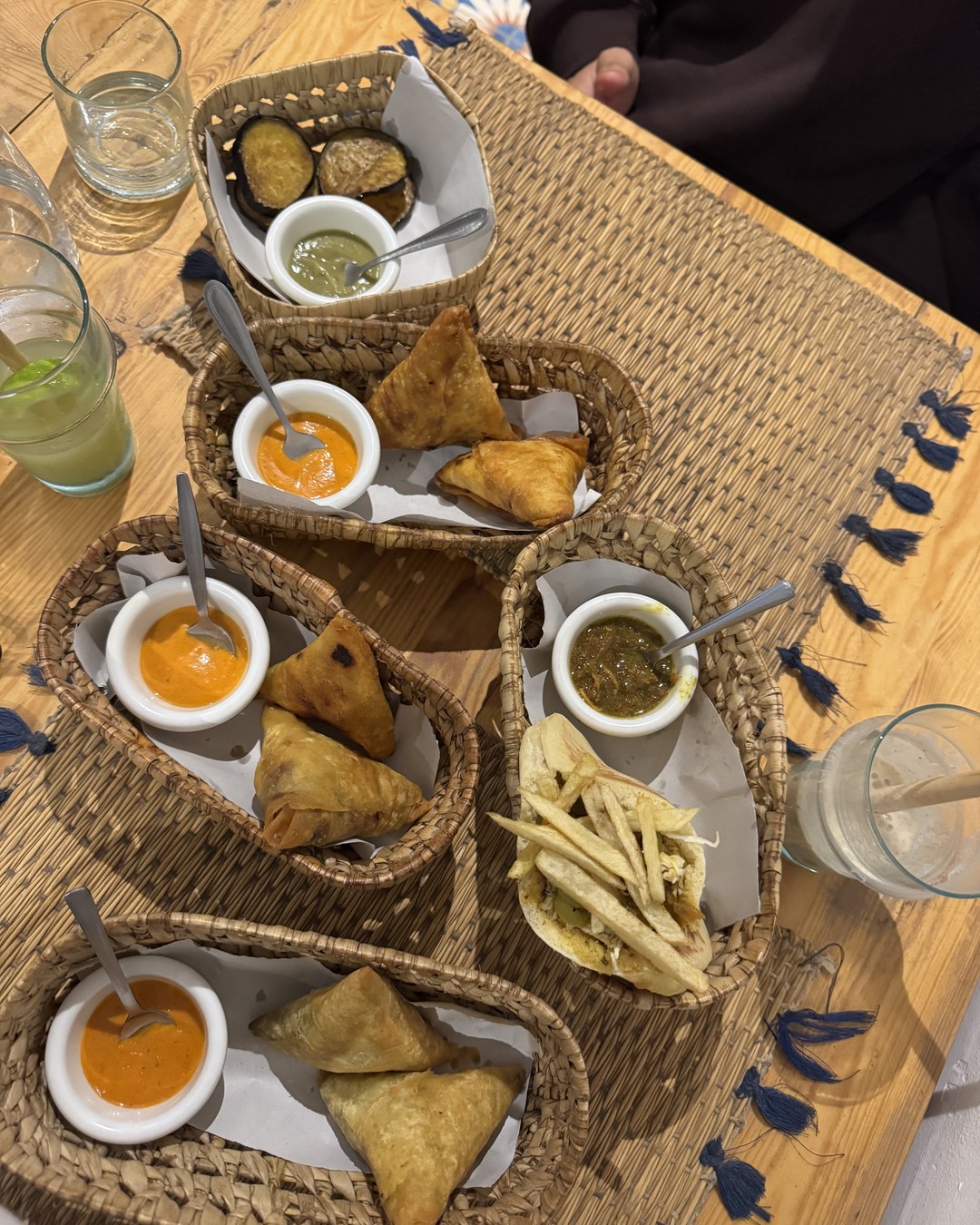 Moroccan pastries and dips served in woven baskets on a table in Tamraght, Morocco