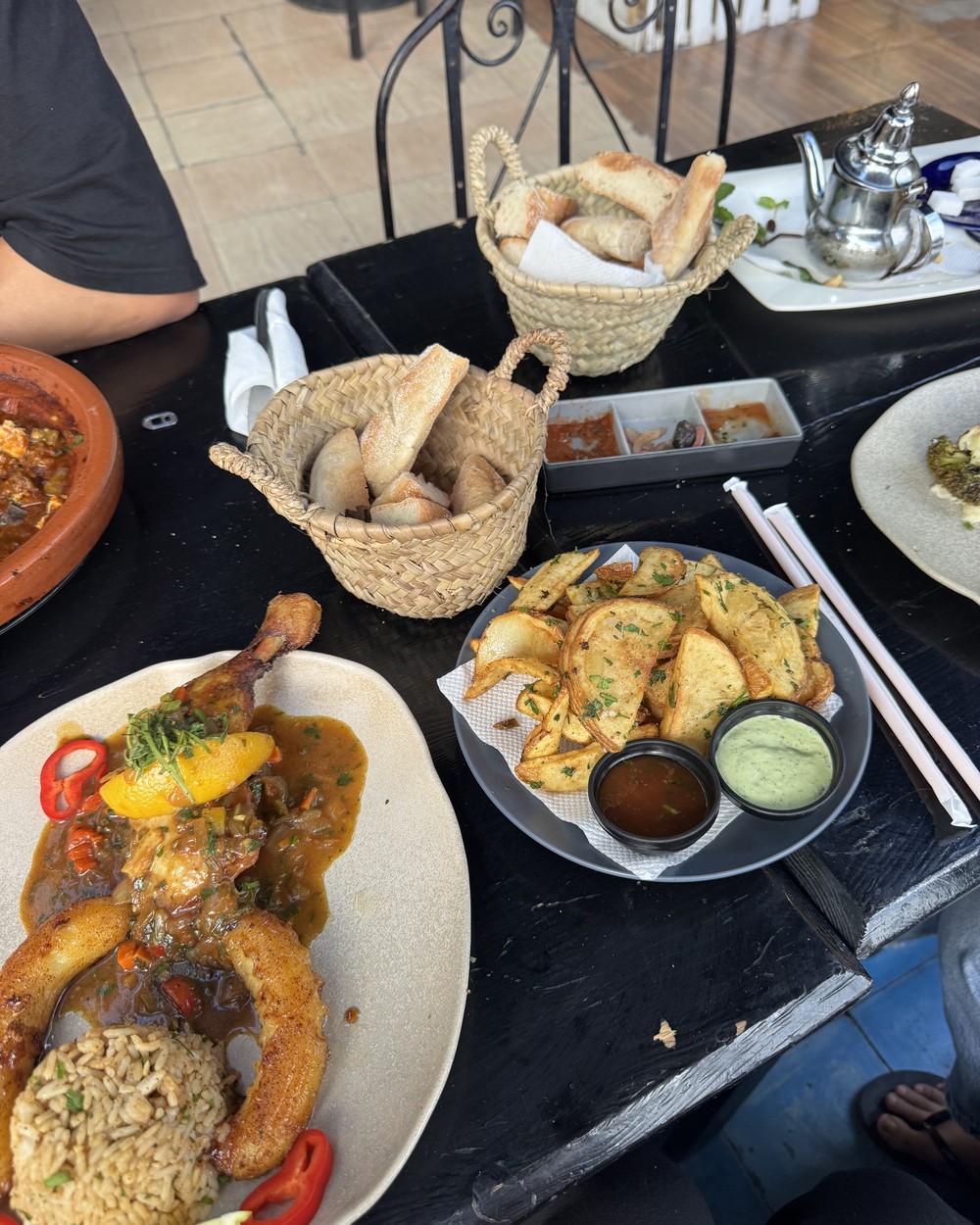 Tagine served with bread, salads and dips on a table in Tamraght, Morocco