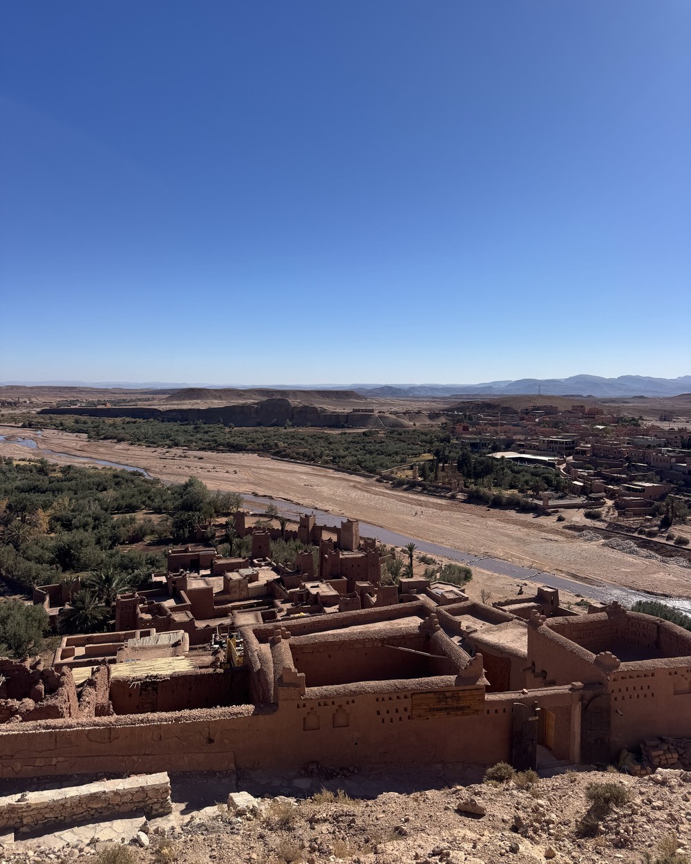Mud brick kasbah village and palm groves seen from above on the road between Marrakech and Merzouga, Morocco