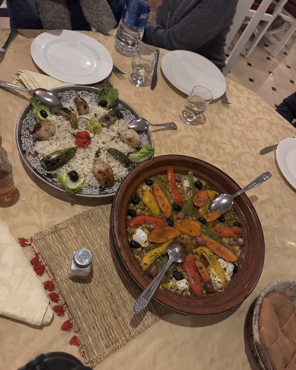 Two Moroccan tagines with vegetables and couscous served on a table during the Sahara desert tour