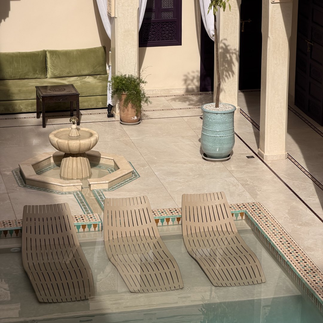 Courtyard pool with sun loungers and a tiled fountain at Palais Andara Riad and Spa in Marrakech, Morocco
