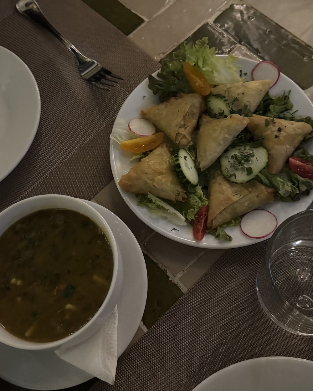 Moroccan soup served with savoury pastries and salad at a riad in Marrakech, Morocco