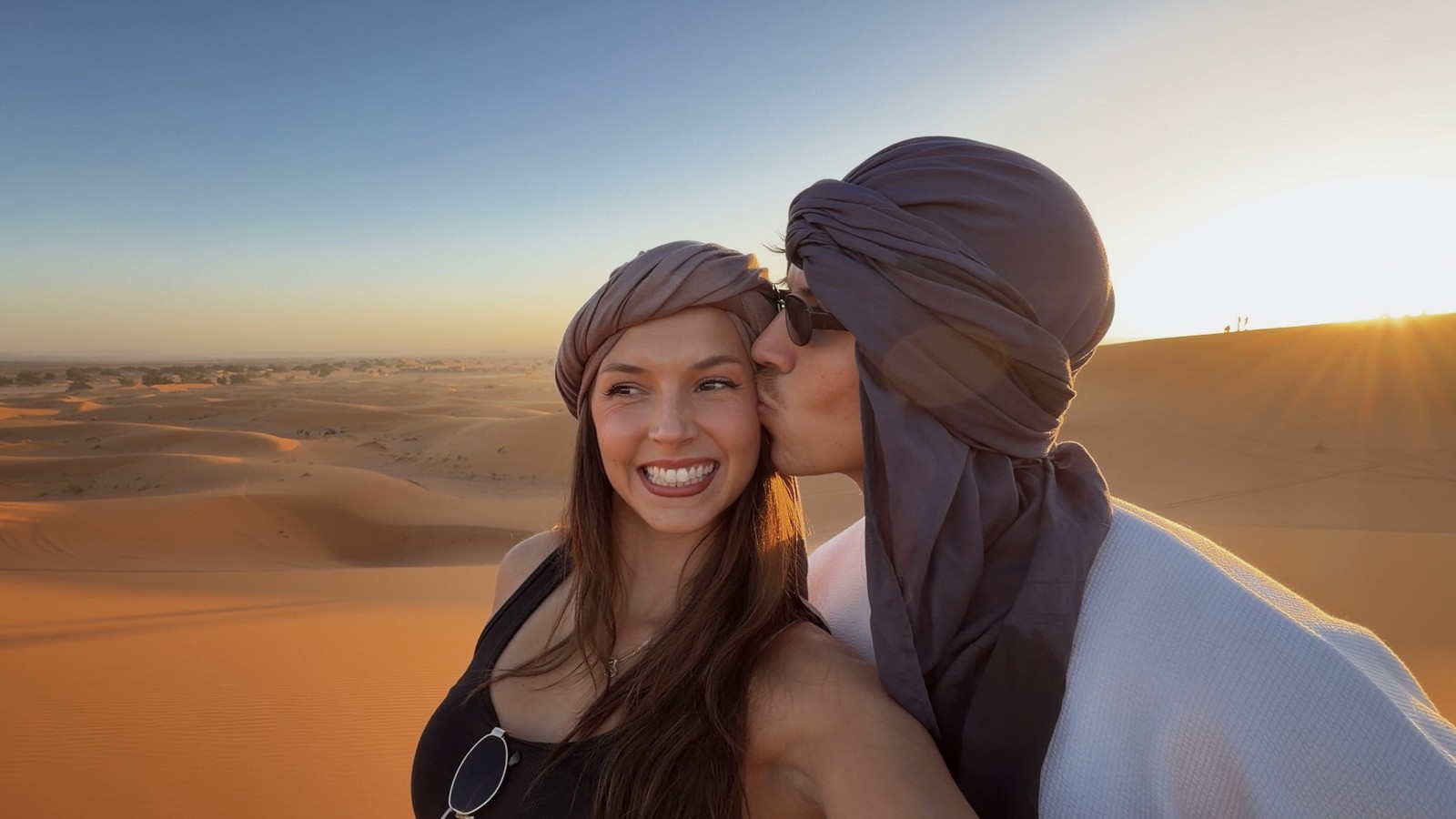 Ellen and Daniel wearing desert scarves at sunset on the dunes of the Sahara at Merzouga, Morocco