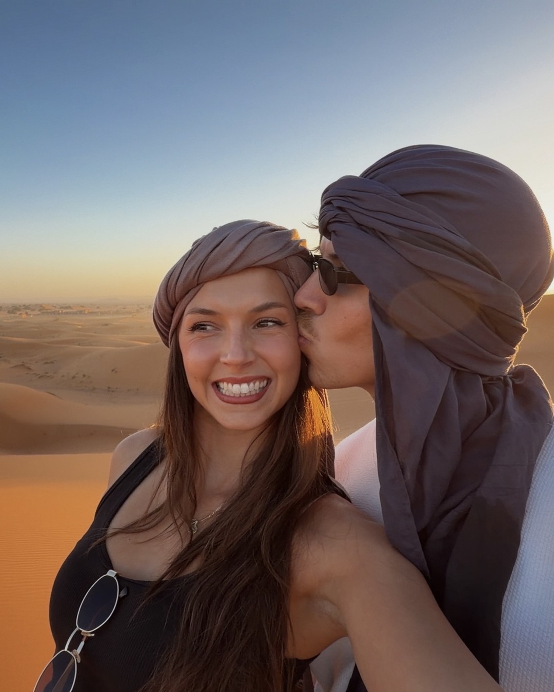Ellen and Daniel wearing desert scarves at sunset on the dunes of the Sahara at Merzouga, Morocco