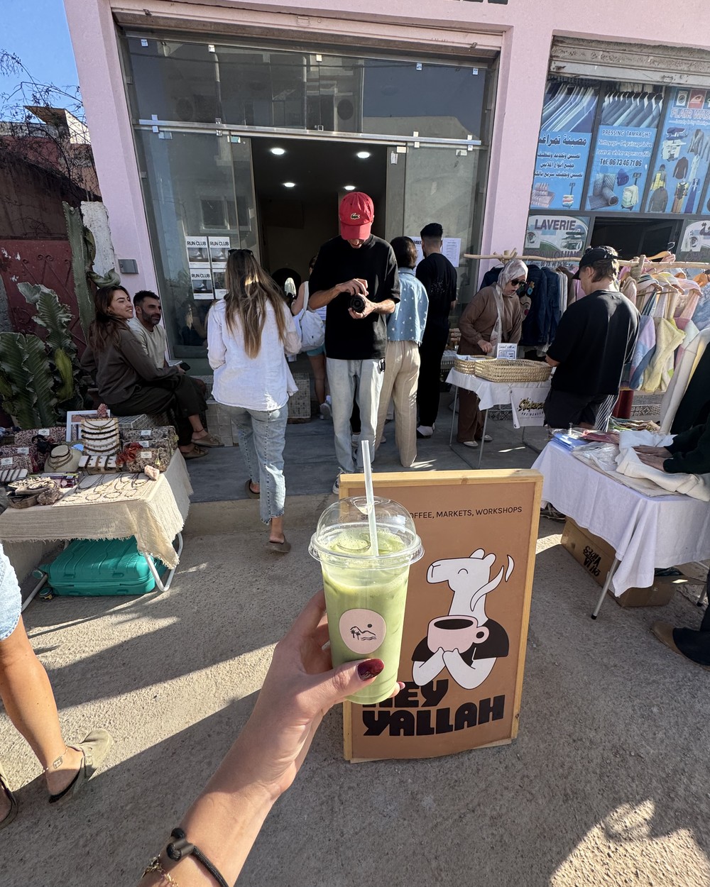 Holding an iced matcha outside the Hey Yallah cafe in Tamraght, Morocco