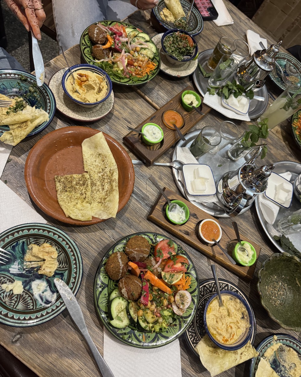 Table covered with Moroccan salads, dips and bread at a restaurant in Tamraght, Morocco